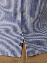 Load image into Gallery viewer, Close-up of a blue and white striped shirt with a brand logo on a beige background