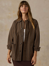 Load image into Gallery viewer, A woman wearing a brown and beige vertically striped button-up shirt jacket over a white top, standing against a textured beige studio backdrop.