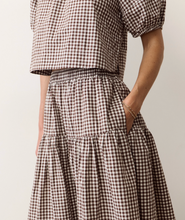Load image into Gallery viewer, Person wearing a brown and white checkered outfit with a neutral background