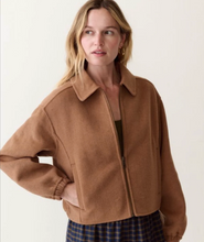Load image into Gallery viewer, Woman wearing a camel colored wool zip front jacket over a plaid skirt in front of a plain cream background