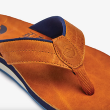Load image into Gallery viewer, Closeup shot of brown leather flip flop details with blue accent trim on a white background