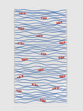 Load image into Gallery viewer, A rectangular white towel with fringed edges, featuring a pattern of blue wavy horizontal lines and small red lobsters scattered across the surface.