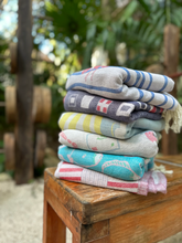 Load image into Gallery viewer, Stack of colorful folded towels on a wooden surface with a natural background
