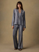 Load image into Gallery viewer, Woman wearing a striped outfit against a beige background