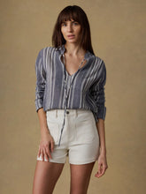 Load image into Gallery viewer, Woman wearing a striped shirt and white shorts against a beige background