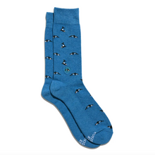 Load image into Gallery viewer, A pair of blue crew socks with an underwater print of orcas, displayed on a clean white background.

