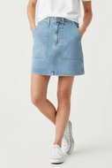 Woman wearing light wash denim skirt with a white tee and sneakers