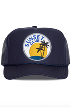 Load image into Gallery viewer, Navy blue trucker hat with 'Sunset Club' logo featuring palm trees and a sunset on a white background.
