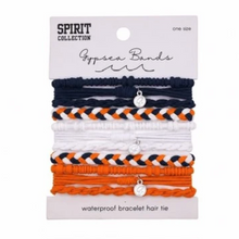 Load image into Gallery viewer, A 4-pack of Spirit Collection Gypsy Bands waterproof bracelet hair ties on a white backing card. The set includes navy blue, white, and orange braided and flat elastic bands, each with a small silver charm.
