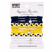 Load image into Gallery viewer, A 5-pack of Spirit Collection Gypsea Bands waterproof bracelet hair ties on a white backing card. The bands are stacked in navy blue, yellow-and-white braided, yellow, navy-and-white braided, and white braided, each with a silver charm.
