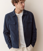 Load image into Gallery viewer, Man in a navy jacket over a striped t-shirt on a plain white background
