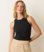 Load image into Gallery viewer, Woman wearing a black sleeveless top and beige pants against a plain background
