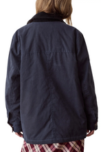 Load image into Gallery viewer, Rear view of a person wearing a dark navy jacket with a black corduroy collar, paired with a red and white plaid skirt, against a plain white background.
