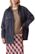 Load image into Gallery viewer, A model wearing a dark navy blue utility jacket over a brown knit sweater and a red, white, and beige plaid skirt, photographed against a solid white background.
