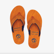 Load image into Gallery viewer, Pair of brown leather flip flops with 'Nokona x Hari Mari' branding on a white background
