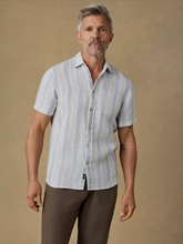 Load image into Gallery viewer, Man wearing a light blue striped shirt and brown pants against a beige background
