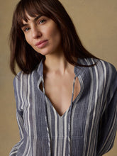 Load image into Gallery viewer, Woman wearing a blue and white striped shirt against a beige background
